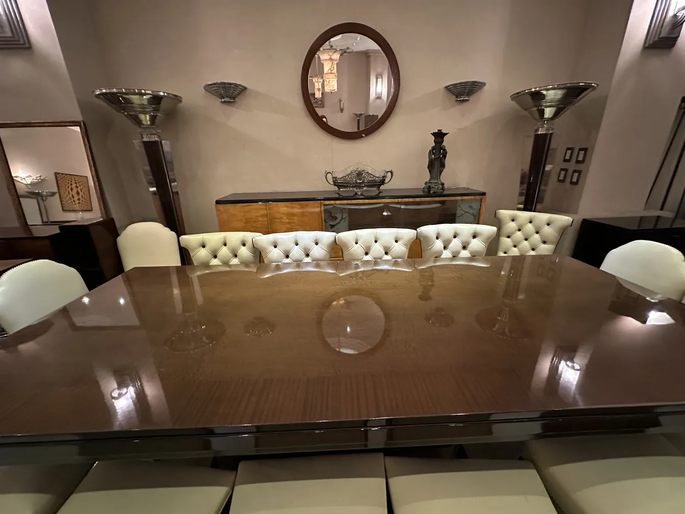 Par de luminárias de parede antigas em um ambiente elegante com mesa e cadeiras.