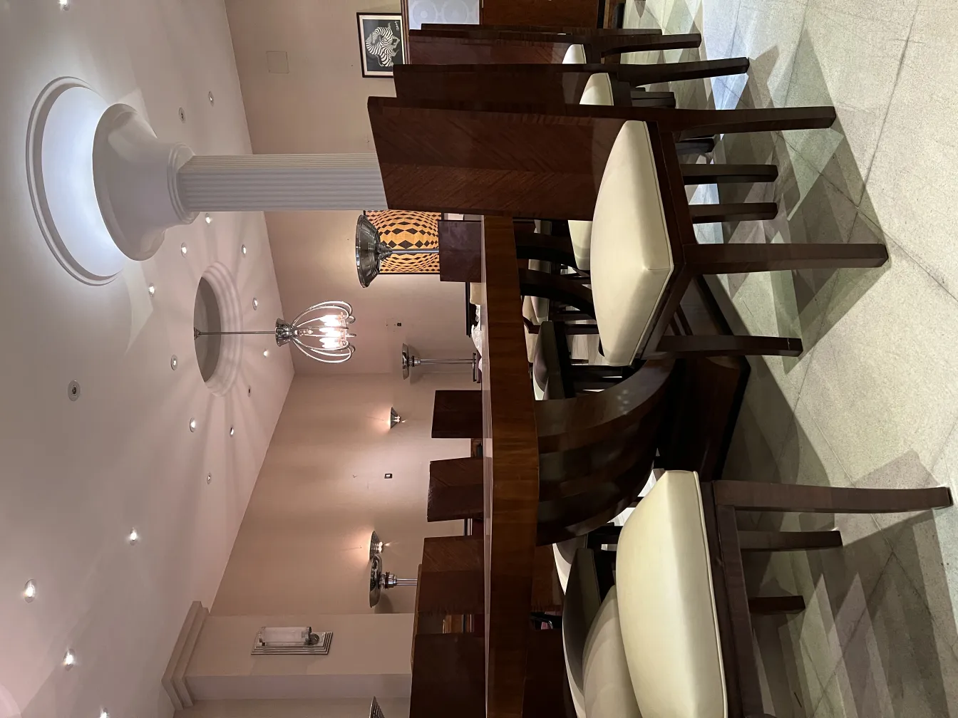 Coppia di applique antiche in un ambiente elegante con sedie in legno.