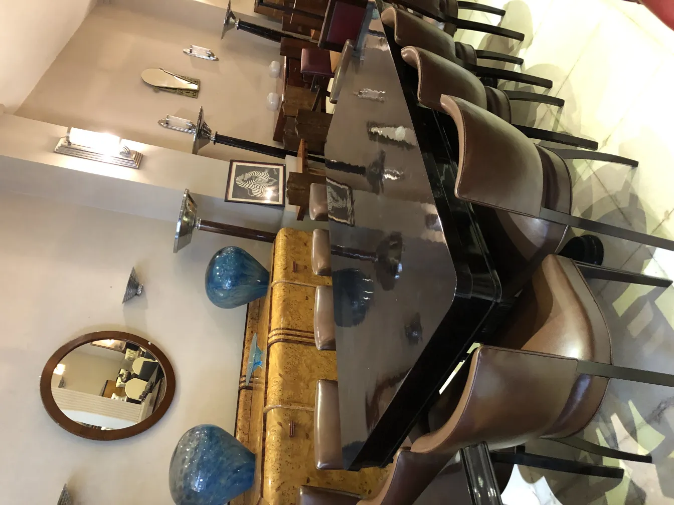 Paire d'appliques anciennes dans un cadre contemporain avec des chaises et de la décoration.