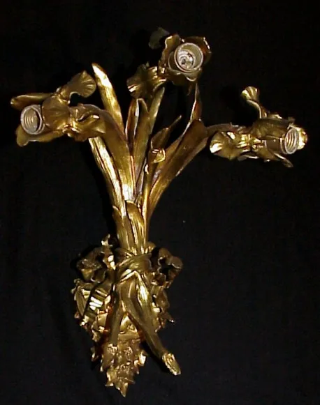 Antike Appliken mit goldenem Rosendesign vor schwarzem Hintergrund.