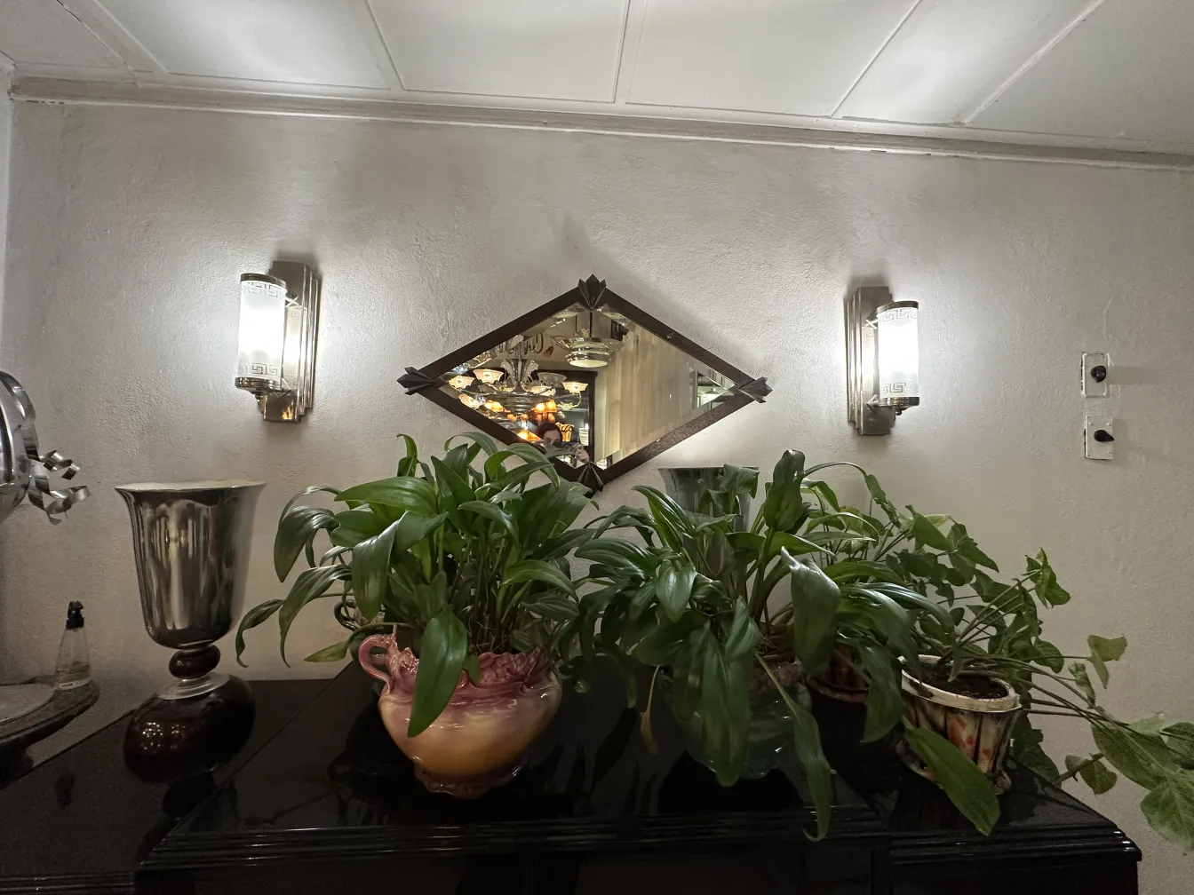 Parede com apliques antigos e decorativos ao lado de plantas