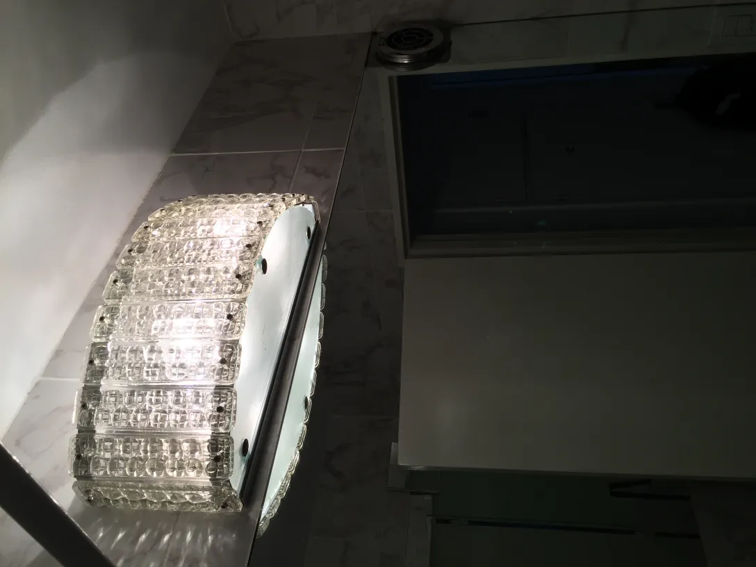 Antikes Glas-Wandleuchter-Paar im beleuchteten Bad