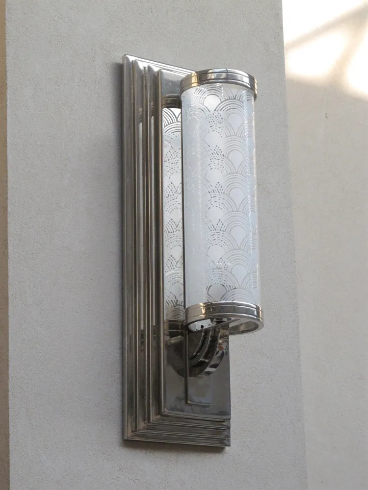 Antique sconces with elegant design on light wall.