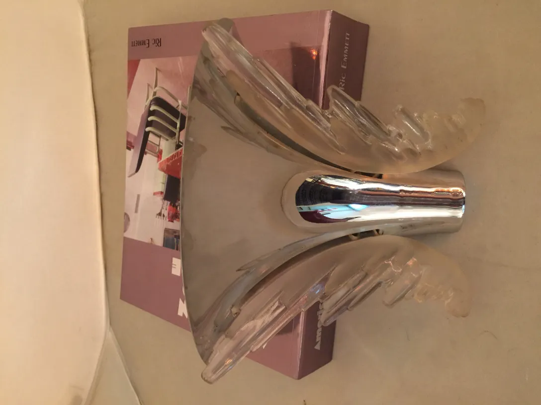 Pair of antique sconces with a unique design, featuring soft curves and shiny details, perfect for enhancing interiors.