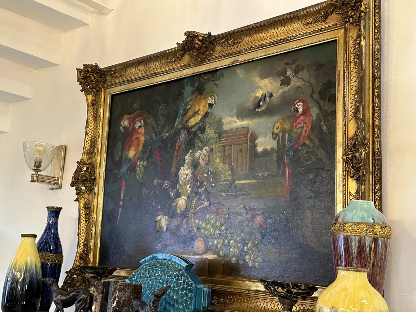 Antique sconces next to a painting and vases