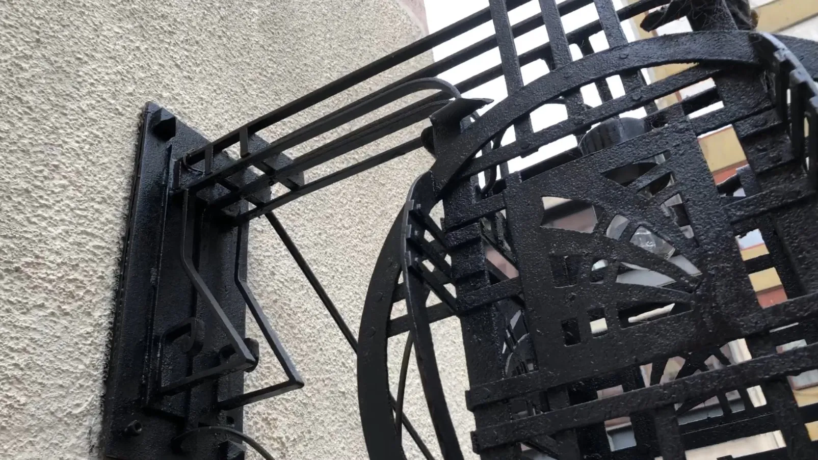 Apliques antigos com design artístico, cor preta, fixados em parede texturizada.