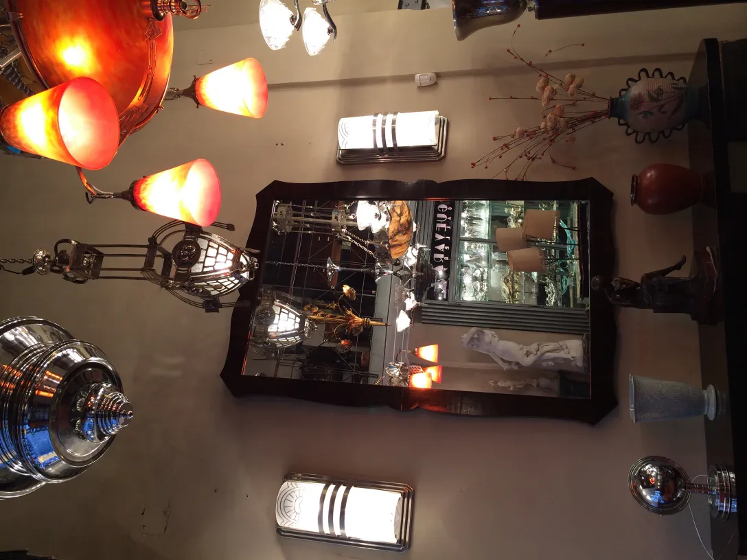 Par de luminárias de parede antigas com luz suave, refletidas em um espelho.