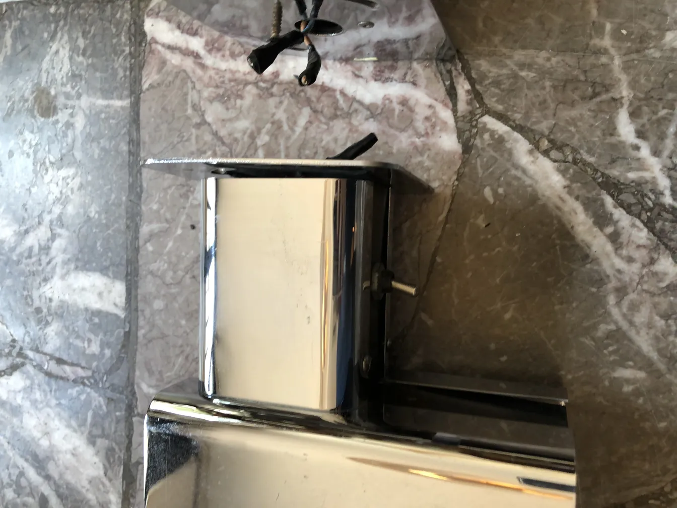 Antique shiny sconces against a marble backdrop.