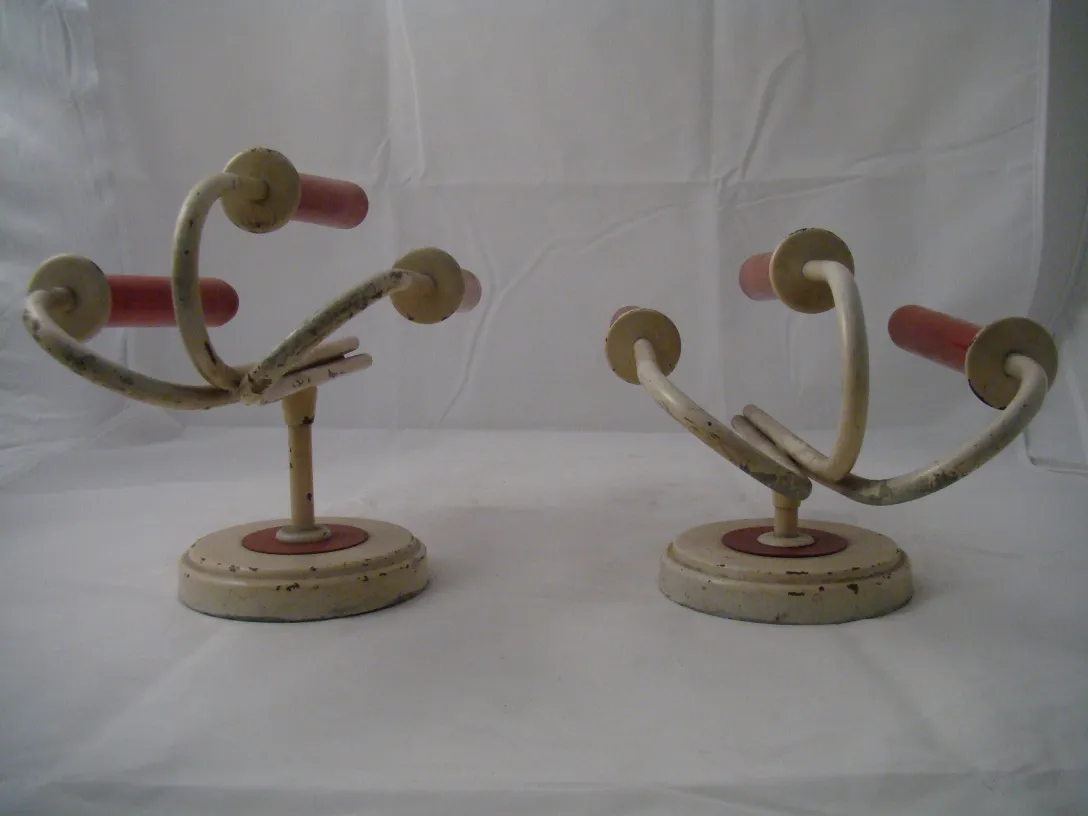 Pair of antique sconces with curved design and soft colors, perfect for decor.