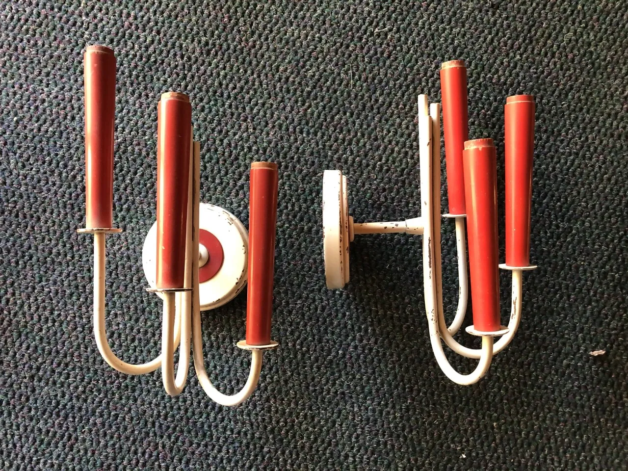 Par de apliques antiguos con detalles en color rojo sobre fondo oscuro