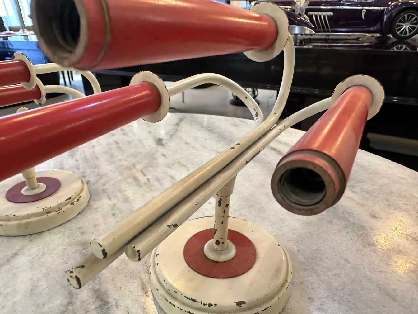 Coppia di applique antiche in rosso e bianco, su un tavolo elegante.