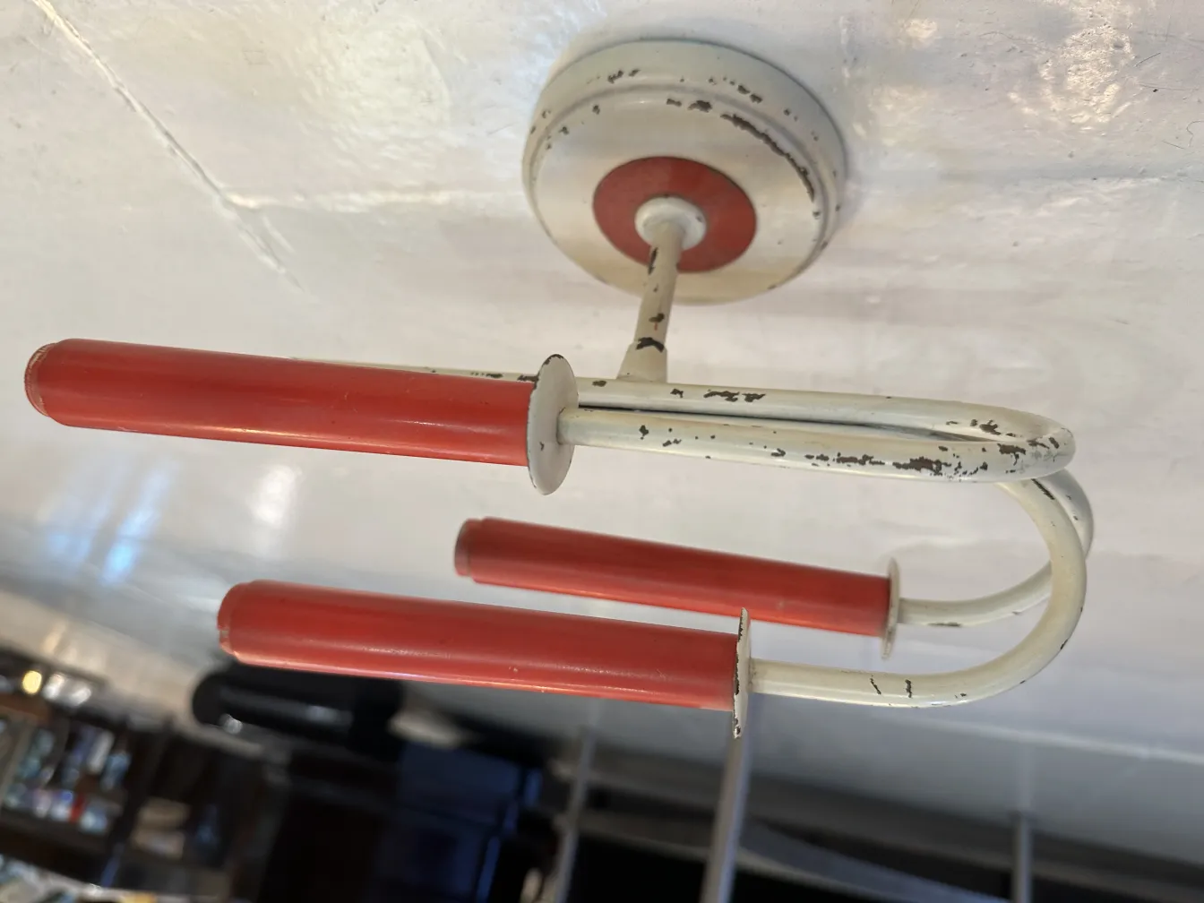 Antique pair of sconces with red details against a light background