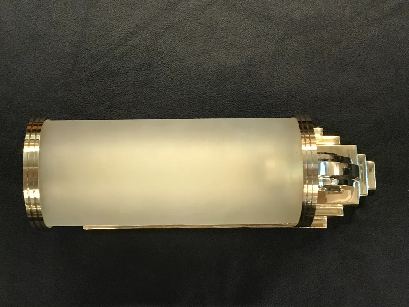 Pair of antique sconces with elegant details, dark ambiance.