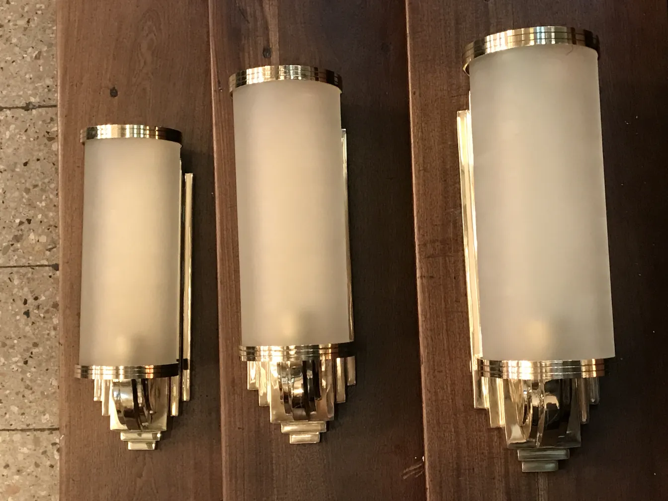 Pair of antique sconces featuring an elegant design and metallic finish