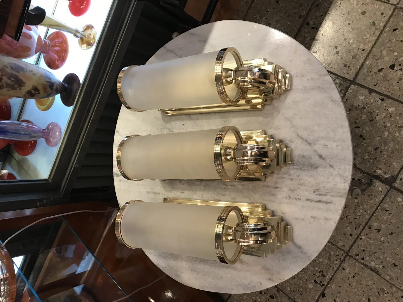 Three antique sconces with etched glass in a stylish setting.