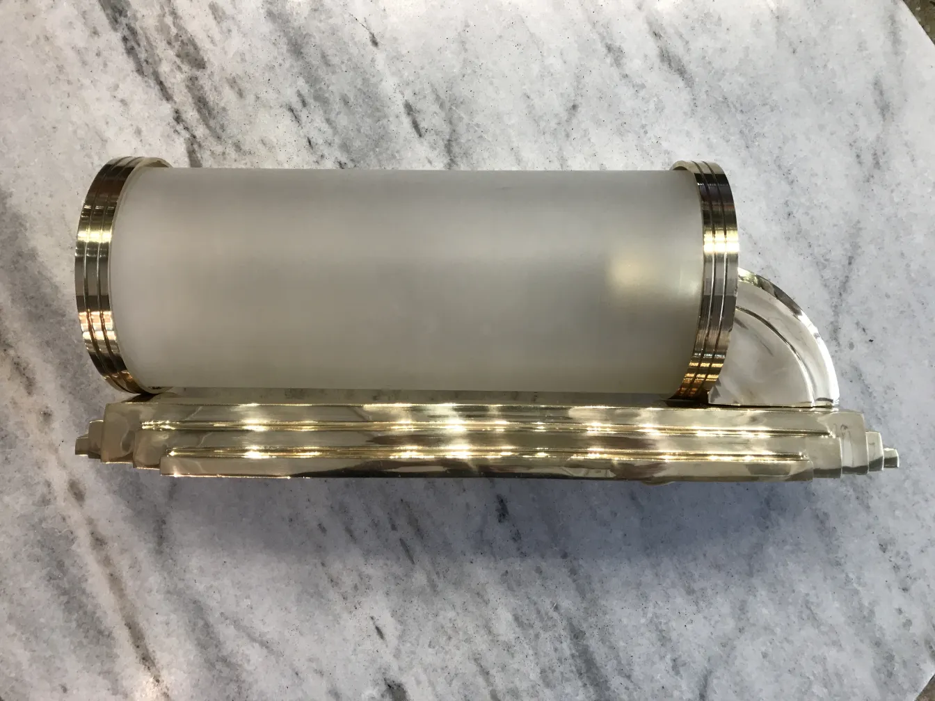 Antique wall light with elegant design and shiny finish, featuring a glass shade