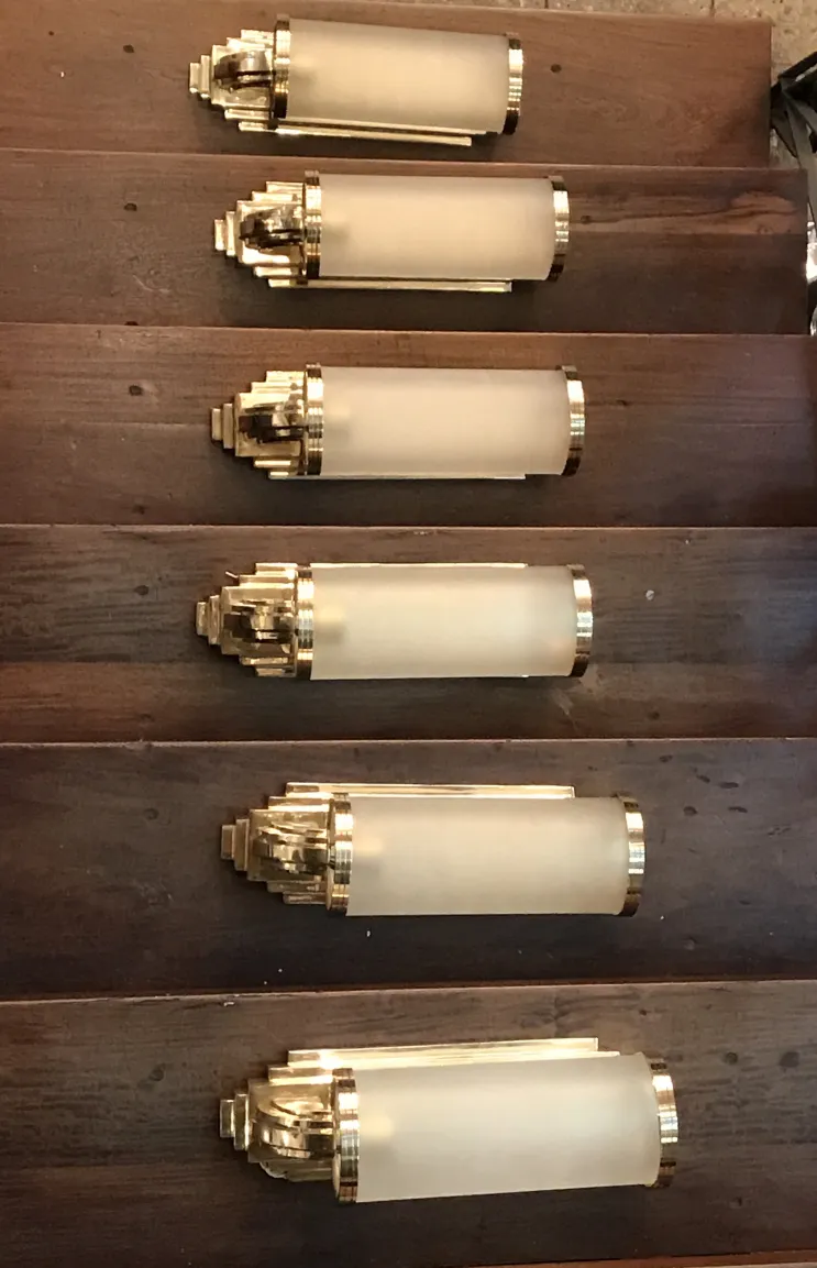 Antica coppia di applique con finitura dorata e vetro smerigliato, decorano scala in legno.