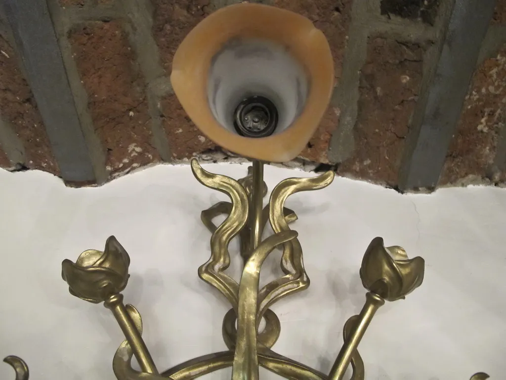 Par de luminárias de parede antigas em forma de flores, detalhe dourado, fundo de tijolo