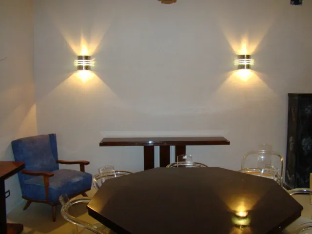 Paar antiker Wandleuchter beleuchtet eine kahle Wand