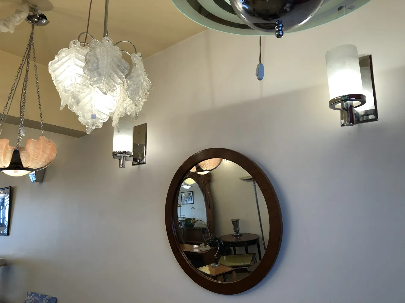 Pair of antique sconces next to a round mirror