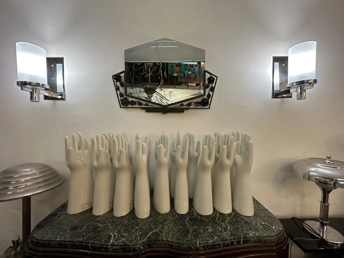 Antique sconces with white hands in the background.