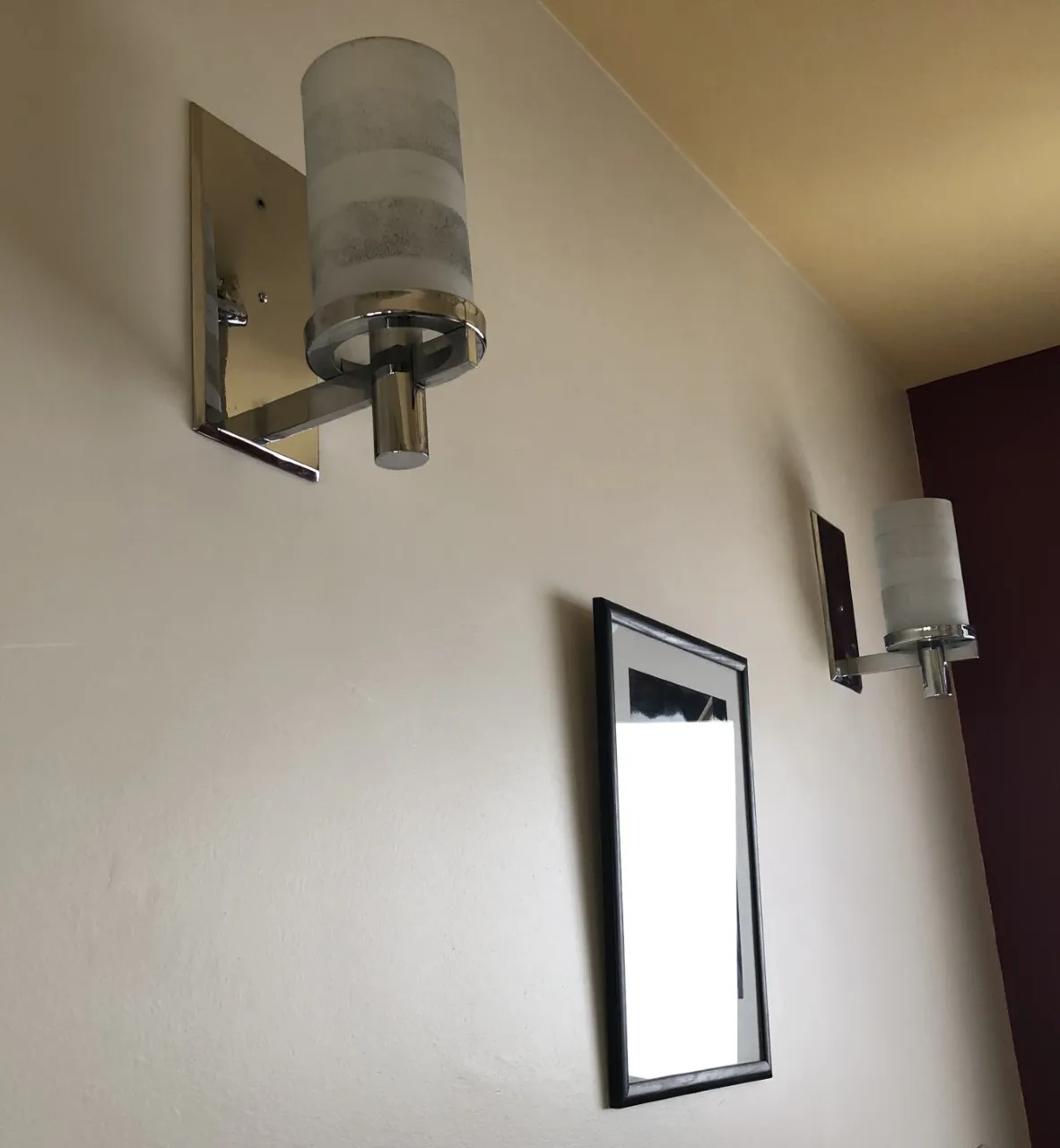 Coppia di applique con paralume in vetro su muro decorativo