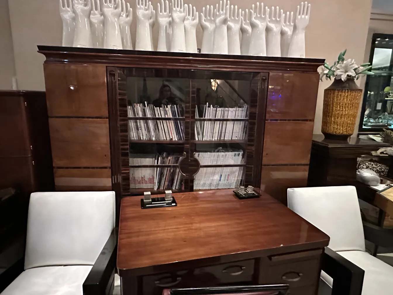 Céramique ancienne dans un cadre décoratif avec des chaises blanches.