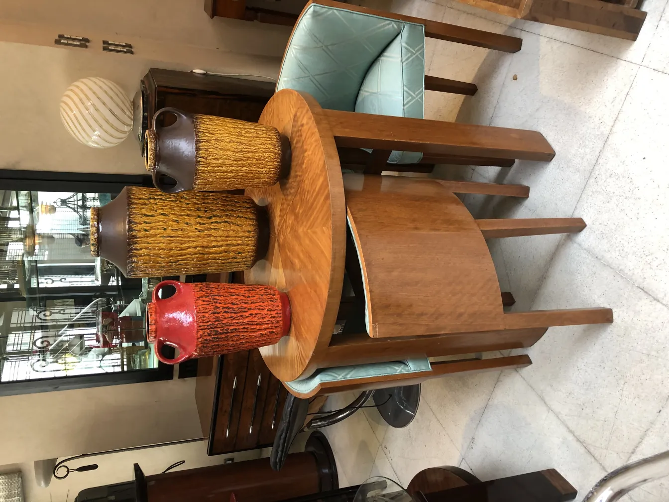 Three colorful antique ceramic vases on a wooden table.