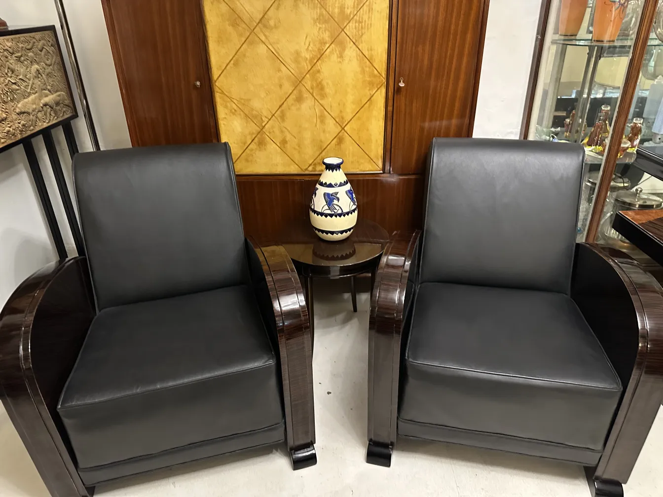 Duas poltronas com uma peça de cerâmica antiga no meio