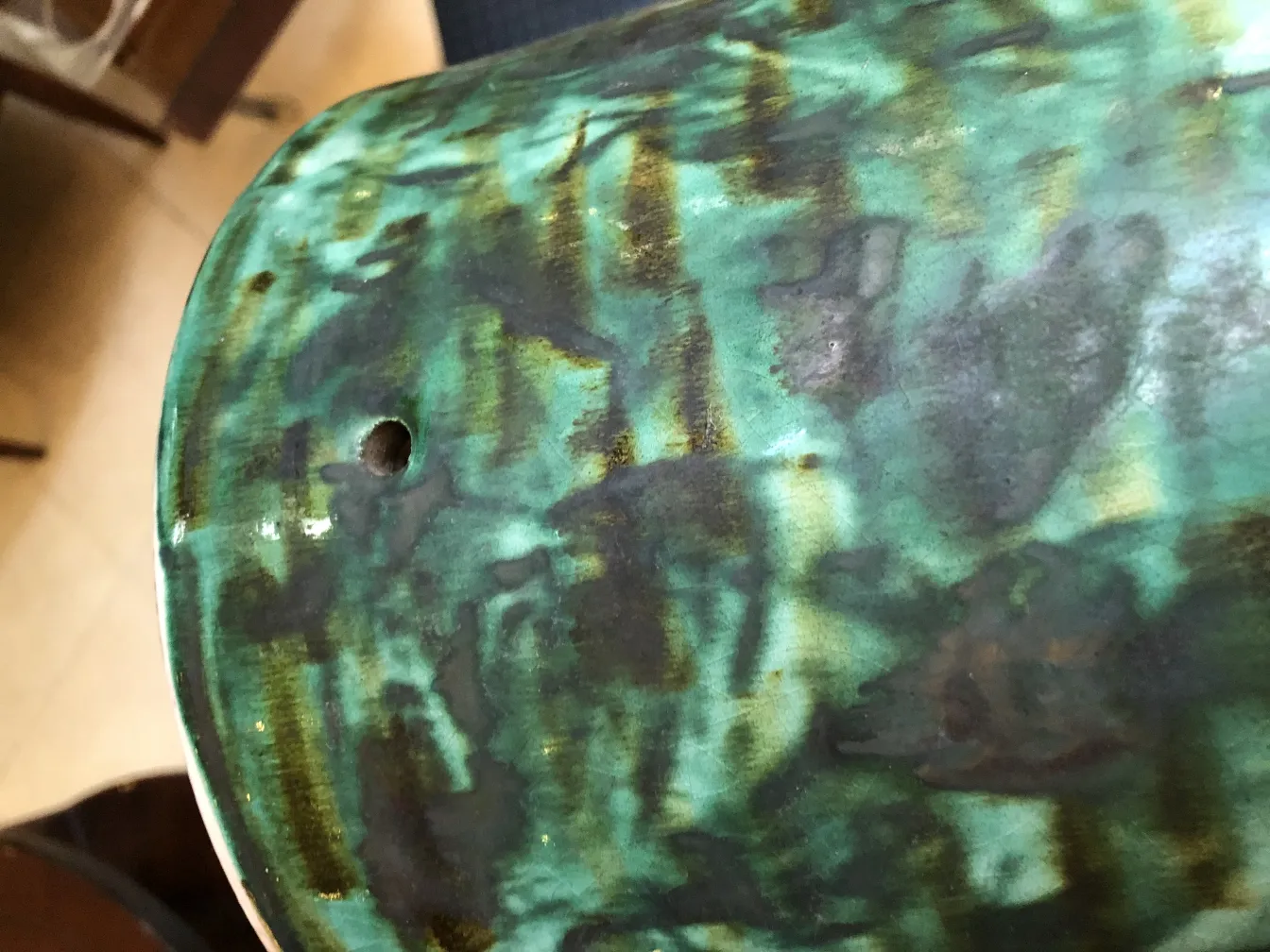 Ceramica antica con tonalità verdi e dettagli scuri