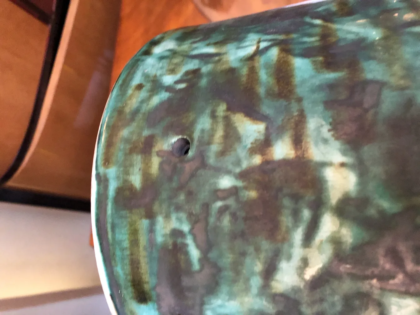 peca antiga de cerâmica com cores verdes e marrons