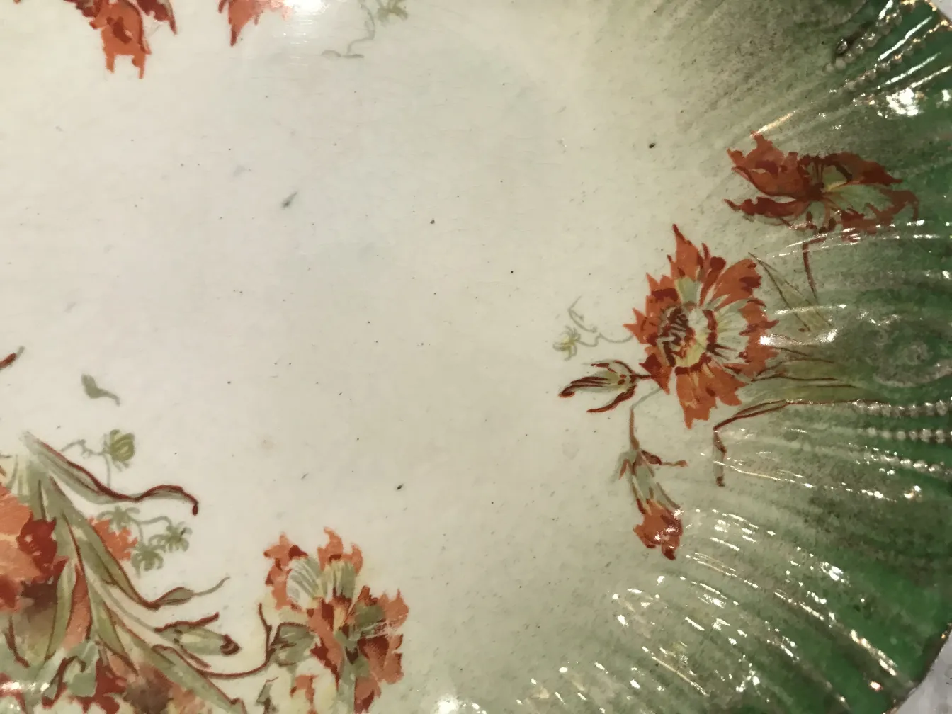 暖かい色の花の装飾が施された古い陶器の皿