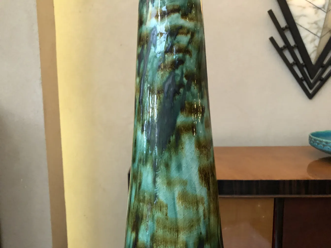 Figura de cerámica antigua en tonos esmeralda con texturas únicas.