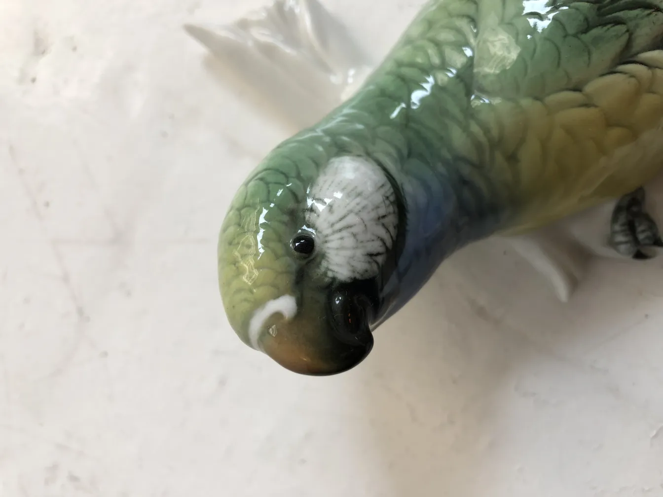 一只古老的陶瓷鸟雕塑，色彩鲜艳。