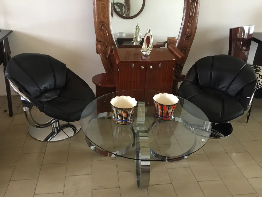 Two antique ceramic pots on a glass table in a modern setting.