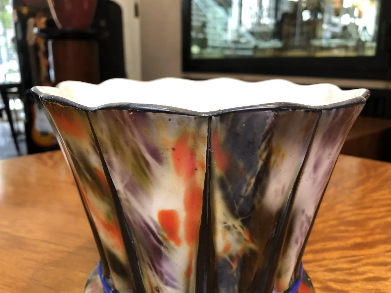 Céramique ancienne colorée avec un design artisanal dans un cadre décoratif.