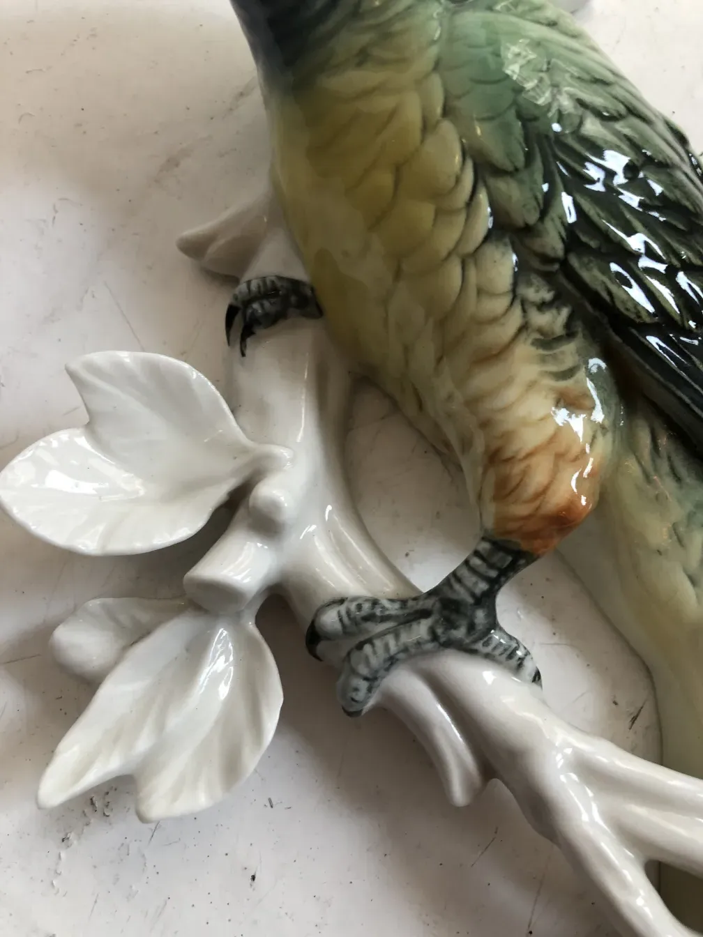 figura de cerâmica antiga com um pássaro em um galho