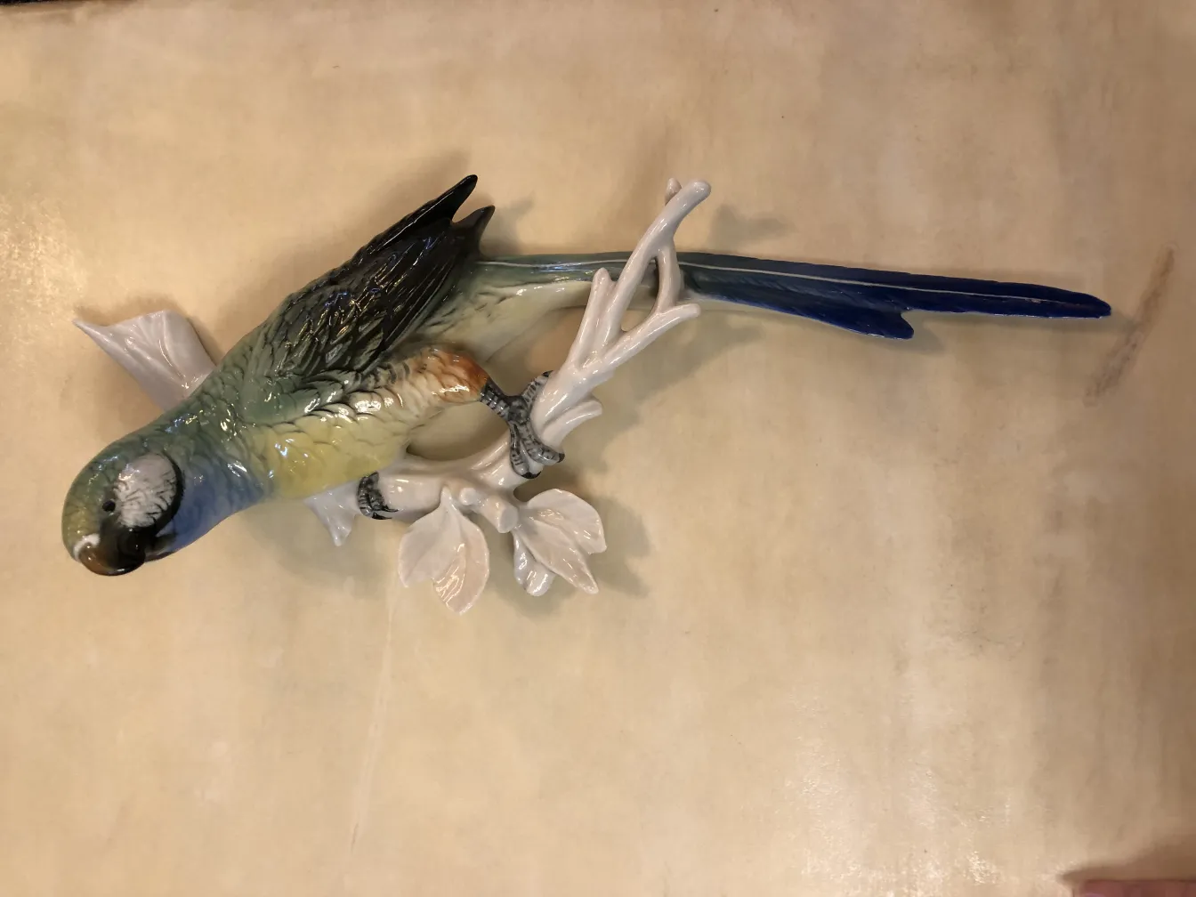 Figurine ancienne en céramique en forme d'oiseau avec des couleurs vives et des détails de feuilles.