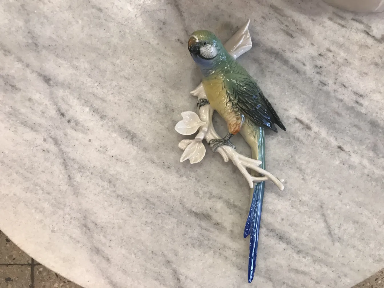 Antike Keramikstatue eines Vogels auf einem Ast mit Blumen