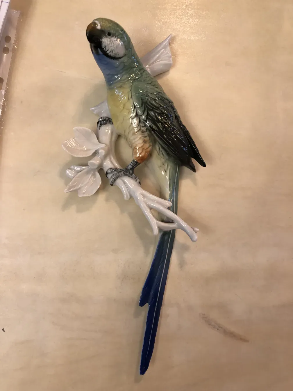 figura decorativa de cerámica antigua con un loro colorido