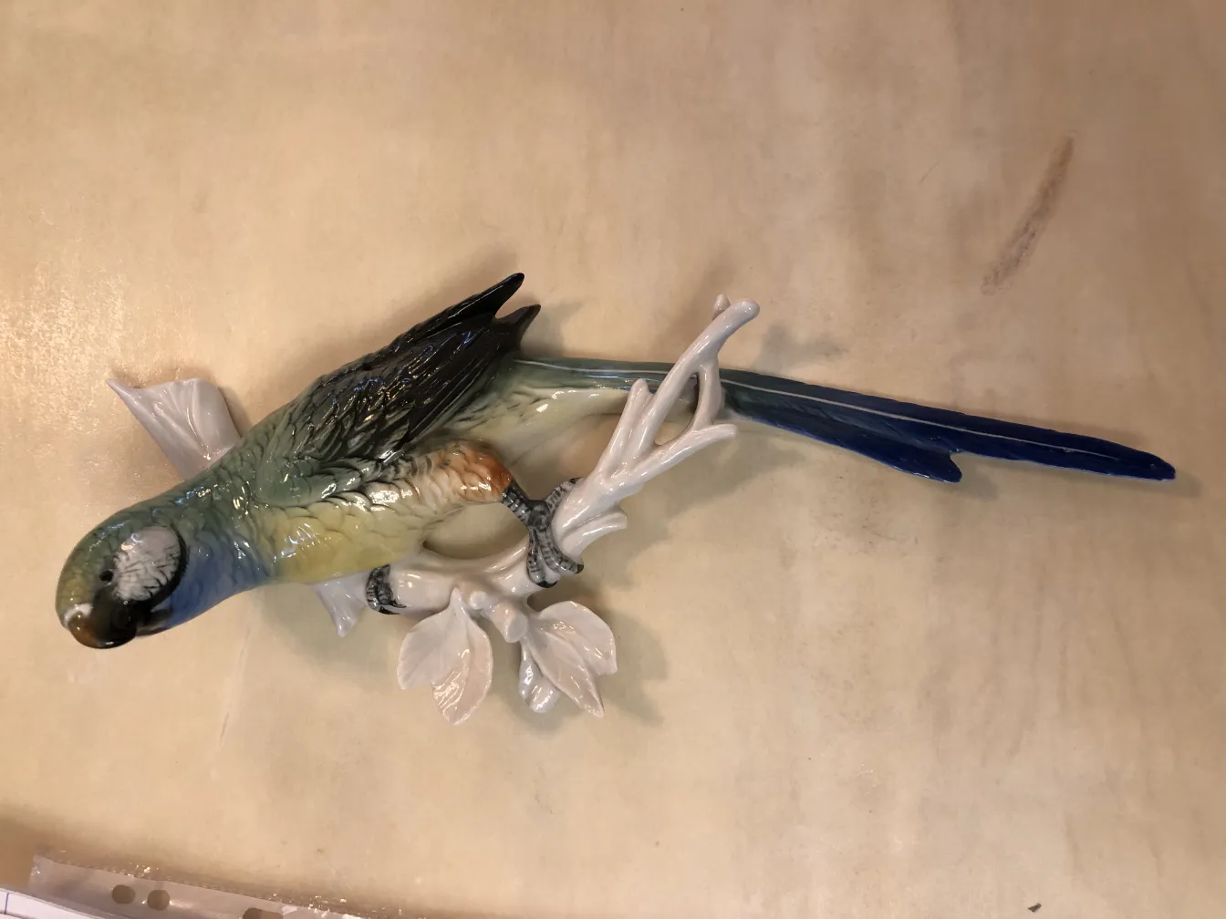 古い陶器の色とりどりの鳥が枝に留まっています