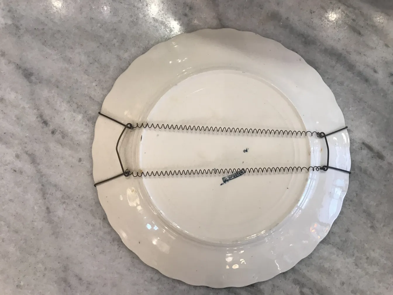 Plato de cerámica antigua con soporte metálico