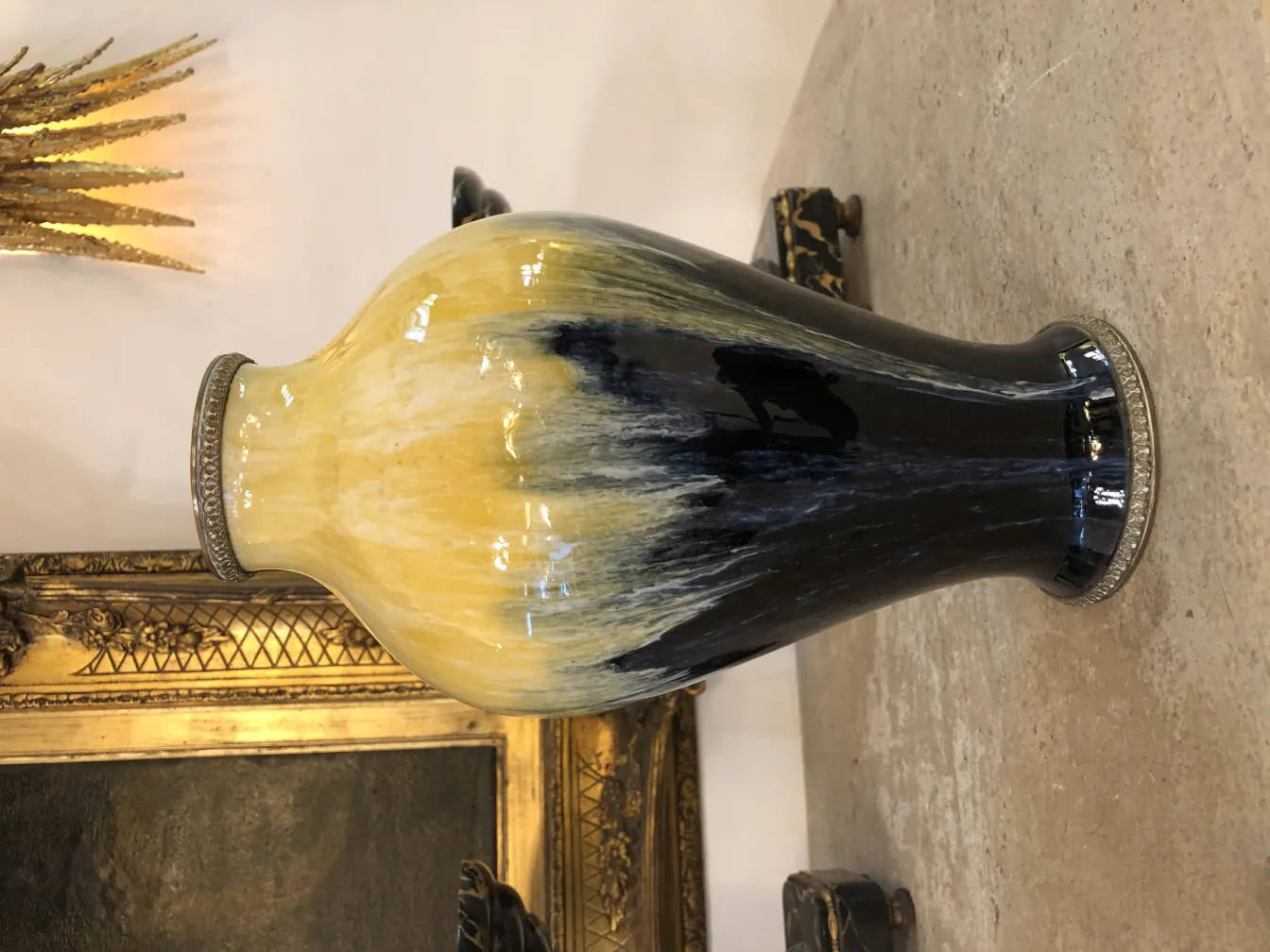Vaso in ceramica antica nero e giallo, con sfondo dorato.
