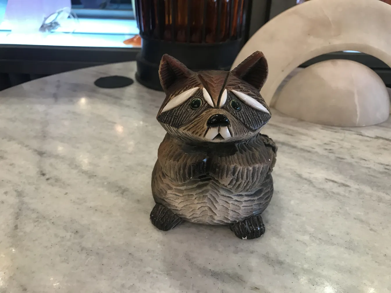 Antike keramische Waschbärfigur in einer modernen Umgebung.