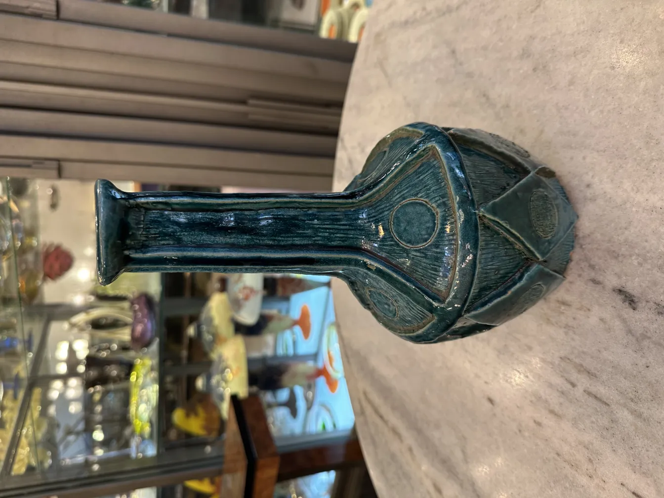 Vase en céramique ancienne de couleur bleue avec des détails gravés.