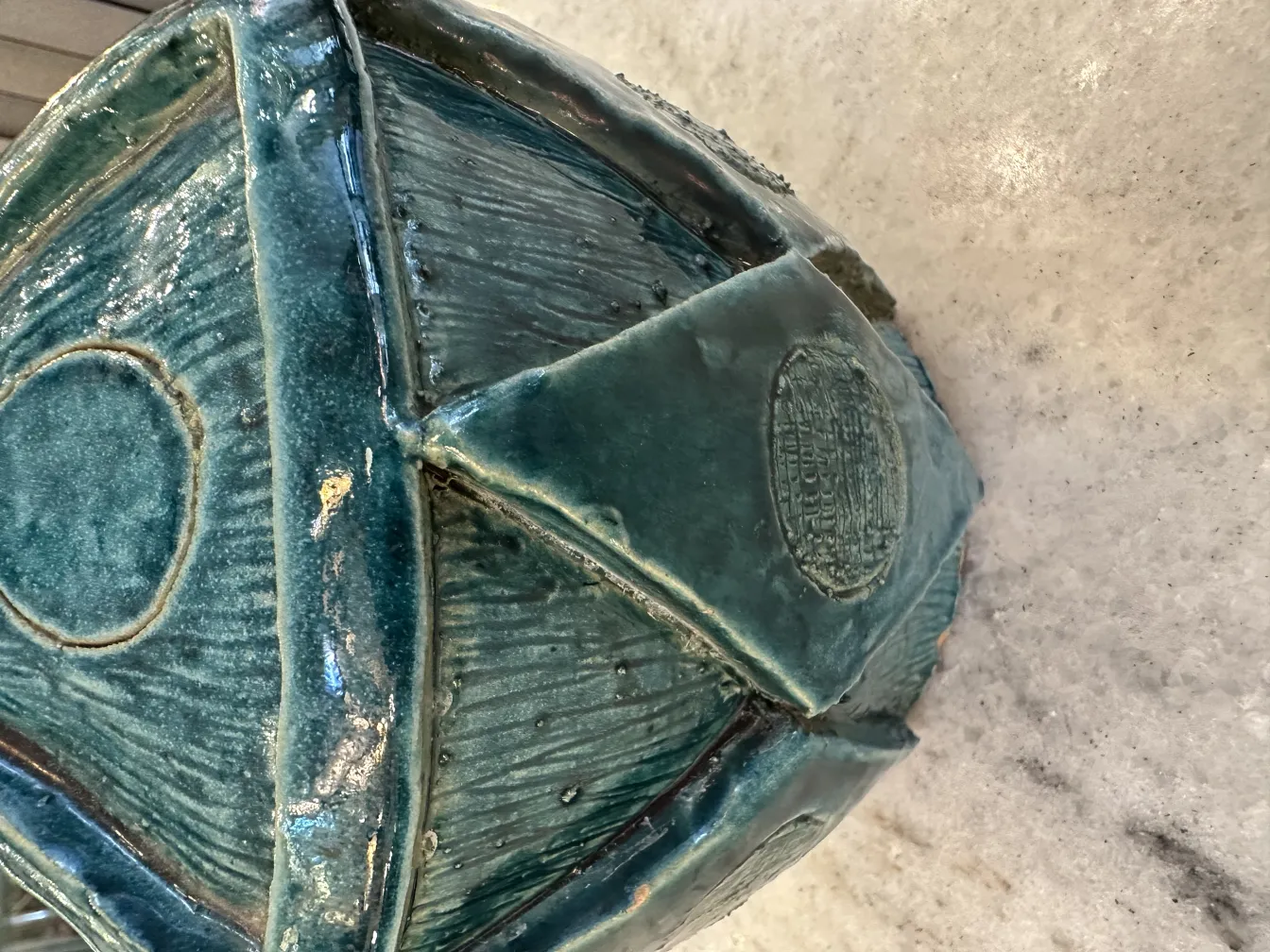 كائن السيراميك القديم الزخرفي بألوان خضراء وزرقاء مع نسيج