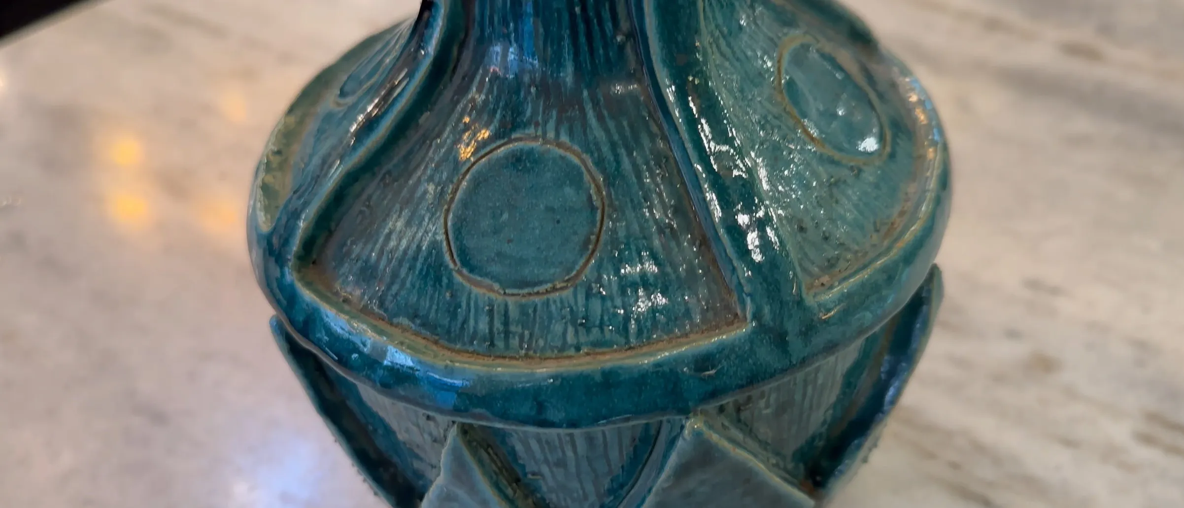 Cerámica antigua con detalles azules y textura distintiva en un entorno elegante.