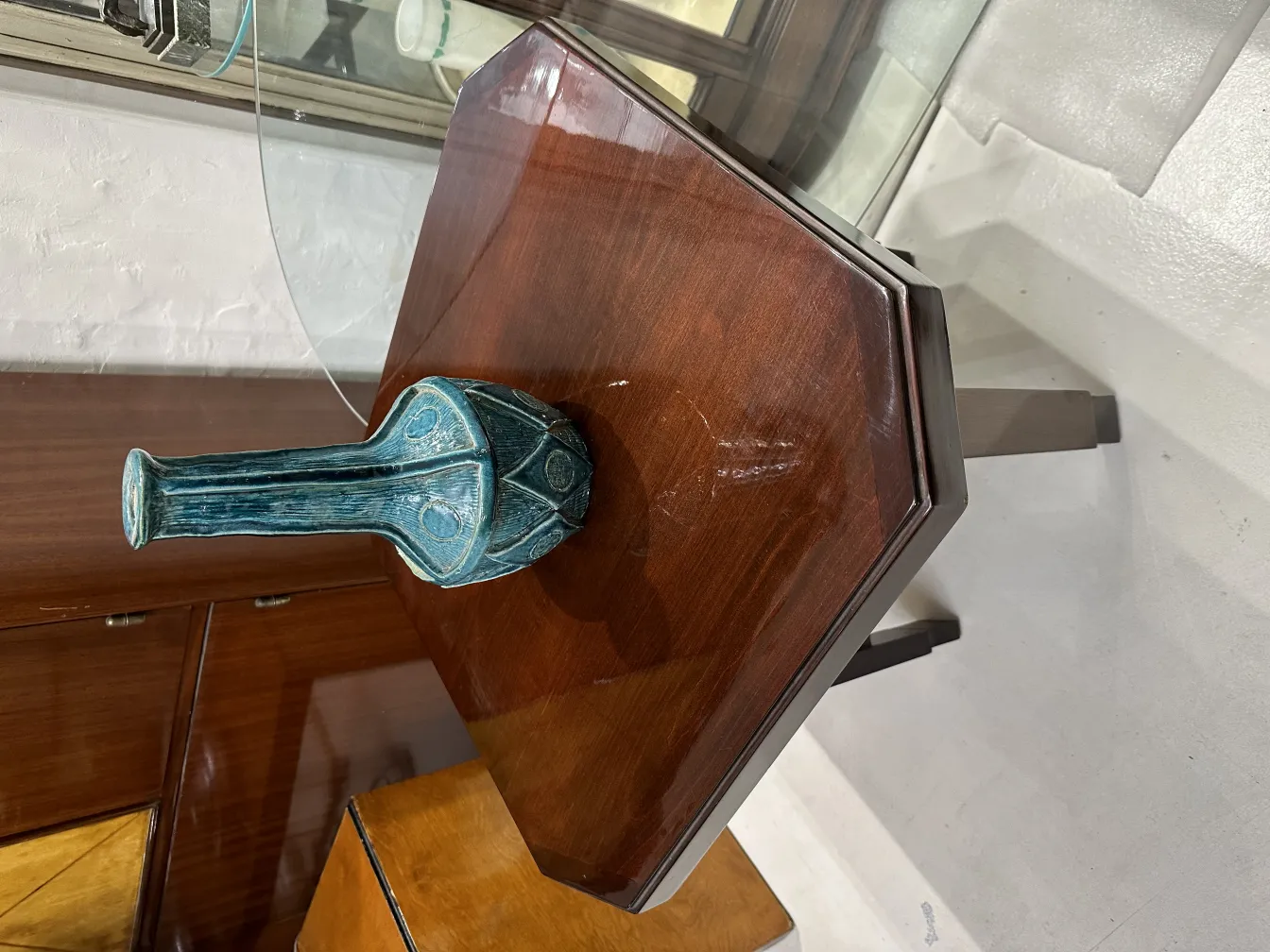 Vaso antigo de cerâmica azul em mesa de madeira