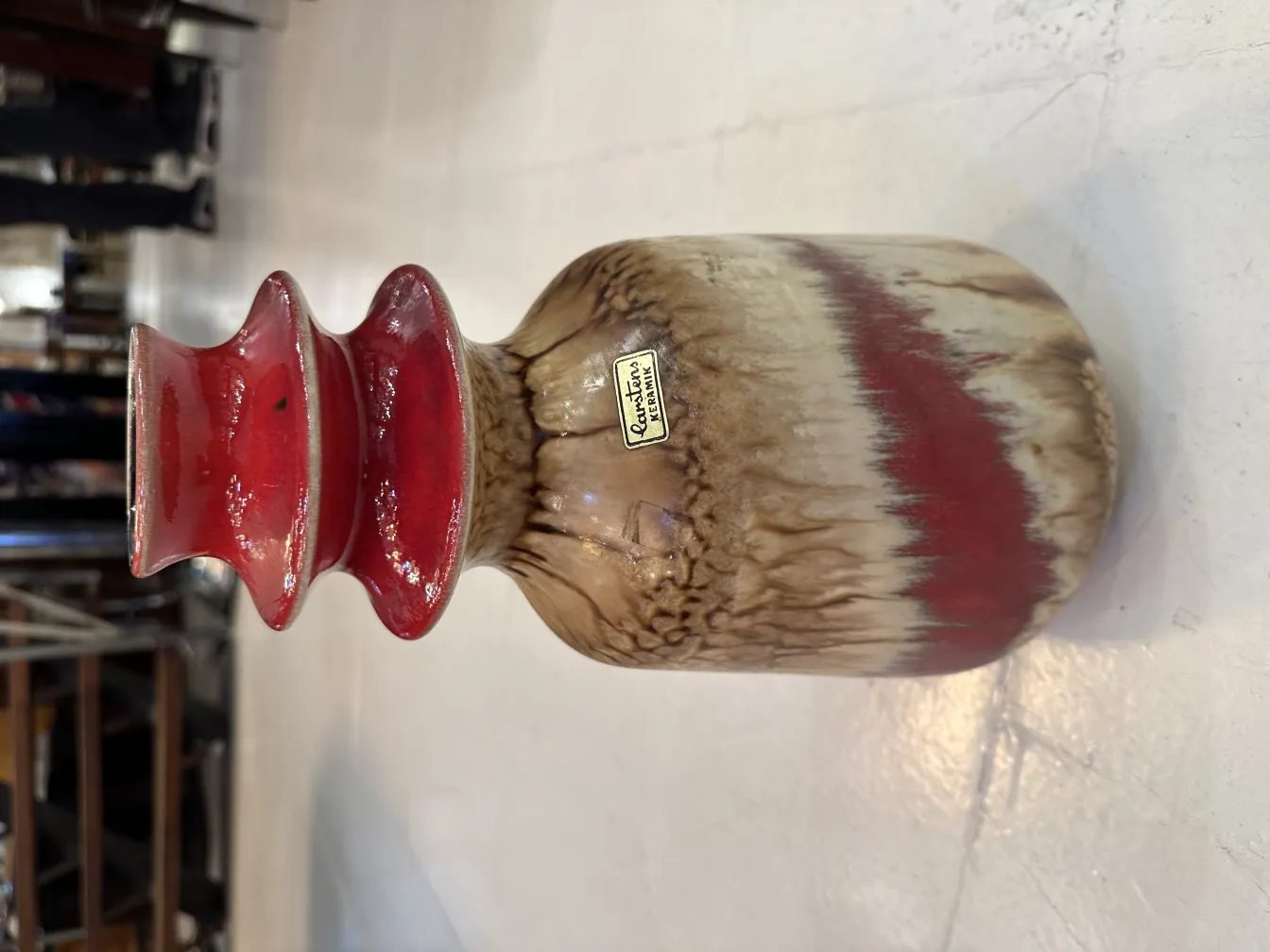 Vaso in ceramica antica con decorazioni in toni rossi e marroni.