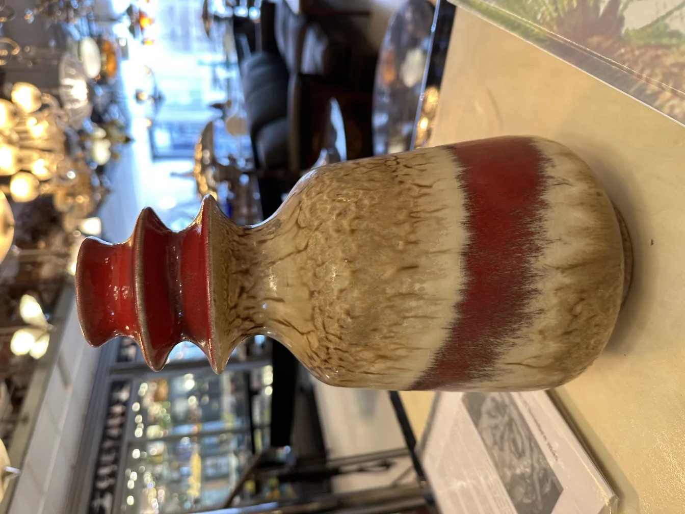 Vase en céramique ancien avec un design décoratif en tons de marron et rouge.